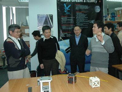 Vũ Trọng Thư (bên phải) giới thiệu về FSpace và vệ tinh F1 với GS Ngô Bảo Châu. Ảnh: NVCC.