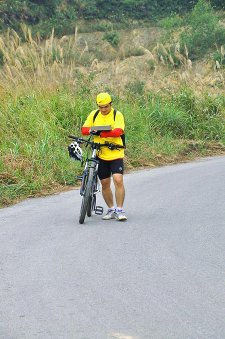 Vừa dắt xe vừa tranh thủ cập nhật facebook.