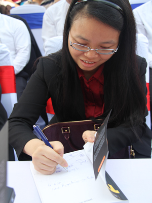 Các lãnh đạo FPT cùng góp chữ ký trong 20 quyển sách gây quỹ Vì cộng đồng. Trong ảnh, chị Hà đang góp chữ ký của mình.