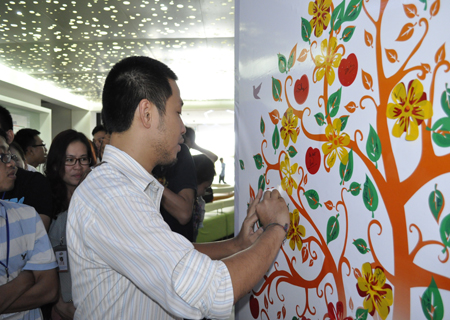 Anh Nguyễn Đức Quỳnh, GĐ FPT Software HCM dán hoa lên cây thiện nguyện.