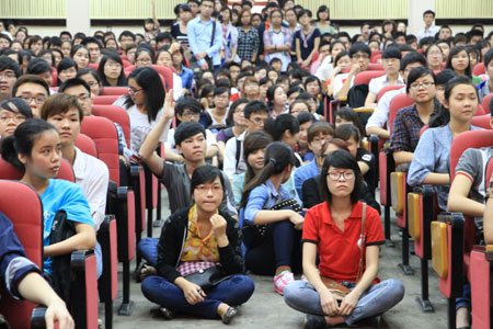 Hội trường ĐH Kinh tế Quốc dân chật kín, nhiều sinh viên phải đứng hoặc ngồi xuống đất để theo dõi. Ảnh: Lâm Thao.