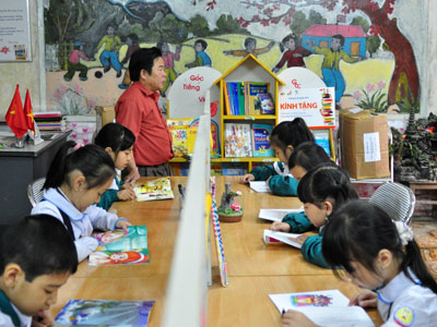 Học sinh trường Tiểu học Mường Khương say mê với tủ sách mới do FPT trao tặng.