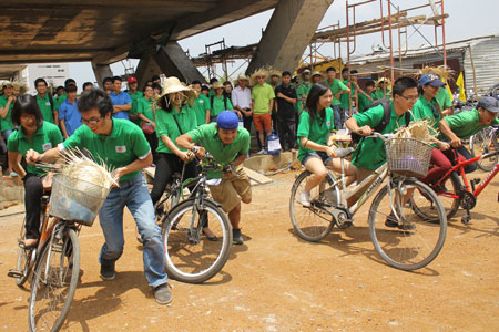 Các vận động viên tranh tài trong cuộc thi phụ: Dắt xe đạp.