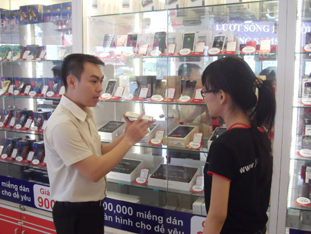 Anh Nguyễn Văn Vạn, giảng viên của Trung tâm đào tạo FPT Retail, hướng dẫn nhân viên mới thực hành tại cửa hàng.