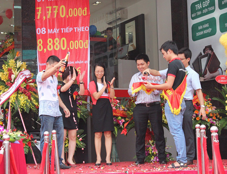 Anh Hoàng Trọng Huân (áo trắng), GĐ Kinh doanh toàn quốc FPT Retail khui champage mừng khai trương.