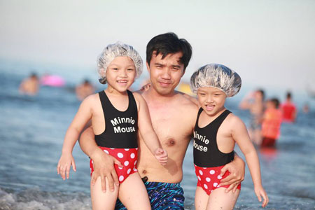 Hai chị em sinh đôi Bảo Linh và Uyển Linh (2008) cùng bố Trương Công Duẩn, ĐH FPT tạo dáng cùng sóng biển. Ảnh: Hà Tiên.