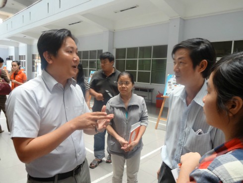 Trưởng phòng Tuyển sinh Lê Bình Trung (trái) trả lời những điều mà phụ huynh quan tâm ngay tại sảnh tòa nhà ĐH FPT. Ảnh: D.K.