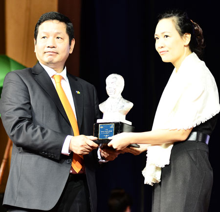 Chị Hồ Hoàng Lan, con dâu cố giáo sư, viện sĩ Nguyễn Văn Đạo, đại diện gia đình, nhận món quà tri ân của FPT.