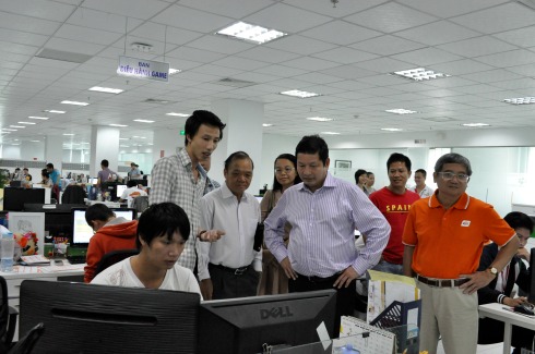 Dừng chân trước màn hình của một nhân viên điều hành game, anh Phạm Công Hoàng - Phó TGĐ FPT Online (áo ca rô) đã giới thiệu về những sản phẩm mà công ty đang và sẽ triển khai.