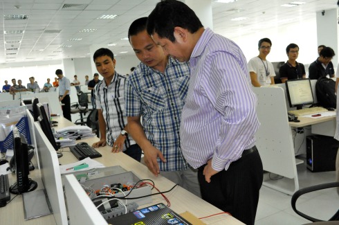 Chia tay tòa nhà, TGĐ FPT Telecom Nguyễn Văn Khoa giới thiệu với Chủ tịch FPT về bộ vi mạch một sản phẩm mà FPT Telecom đang triển khai.