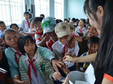 Các tình nguyện viên của Hội Người Phú Ninh tại Đà Nẵng, những người tham gia đoàn, phát bánh kẹo cho các học trinh trước giờ tặng quà.