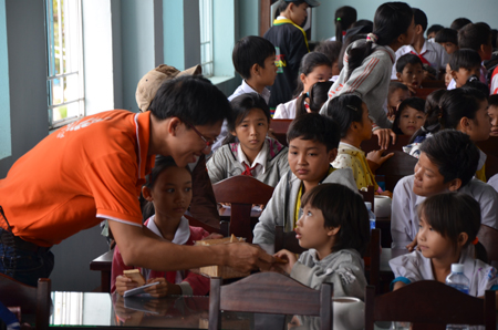 Trong khi chờ đến giờ làm lễ, anh Nguyễn Tiến Danh, Trợ lý Ban Giám đốc FPT HCM, tặng các phần bánh kẹo cho các em nhỏ.