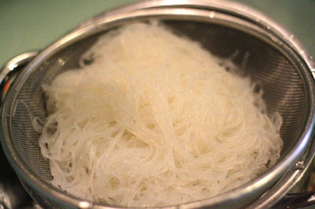 Đun nóng nồi nước sôi cho miến vào chần sơ, vớt miến ra rổ và xả lại nước lạnh để miến không bị dính chùm, để lên rổ cho ráo nước.
