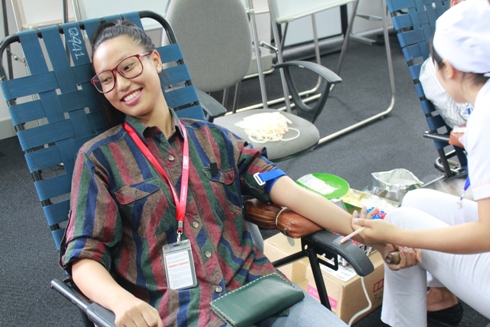 Chị Đào Thị Bịch Trâm, bộ phận tuyển dụng, tươi cười khi bác sỹ bắt đầu hiến máu.