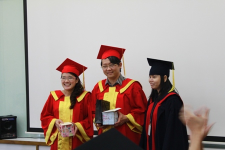 Chị Nguyễn Thị Mai Anh (bên trái) cùng anh Trần Đức Hải Triều (áo đỏ ở giữa) - hai giảng viên của lớp - nhận quà lưu niệm từ học viên.