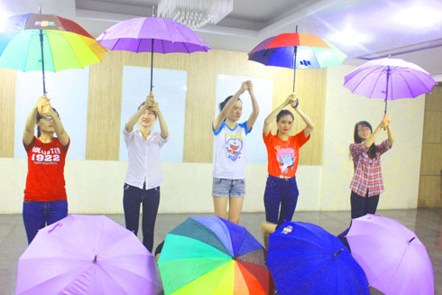 Một top nữ gồm 9 CBNV đang tập luyện múa bằng chiếc ô.