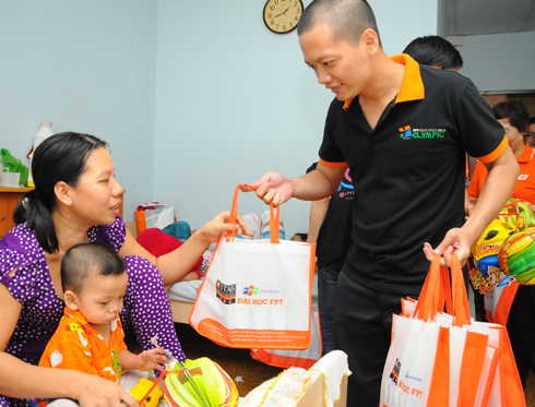 Anh Lê Đức Duyên, phòng Công tác Sinh viên, ĐH FPT, tặng quà cho bé Nguyễn Tấn Phát, quê Đồng Tháp.