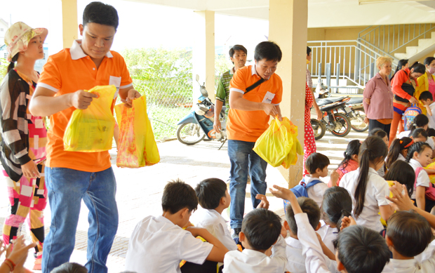 Các thành viên trong đoàn lần lượt phát quà cho học sinh của trường. Mỗi suất quà tặng trị giá khoảng 100.000 đồng, gồm vở, bút viết, bánh kẹo, sữa.