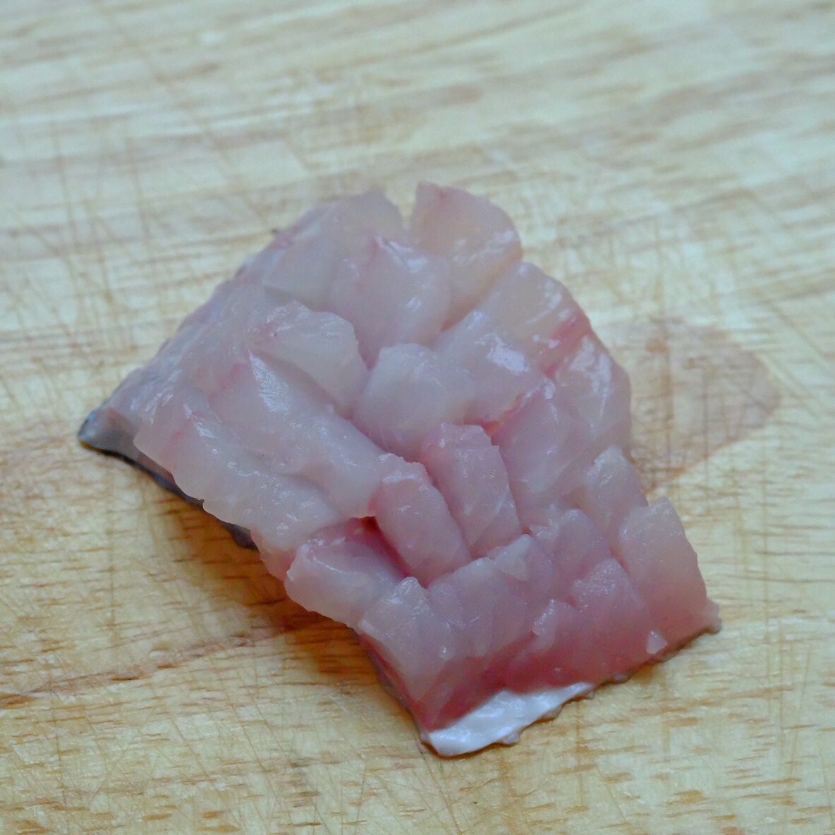 <p> <strong>Bước 1: </strong>Cắt cá thành những miếng có khổ gần 5 cm, sau đó khứa các ô vuông bằng nhau ở mặt thịt cá. Khứa gần sát đến lớp da cá.</p>