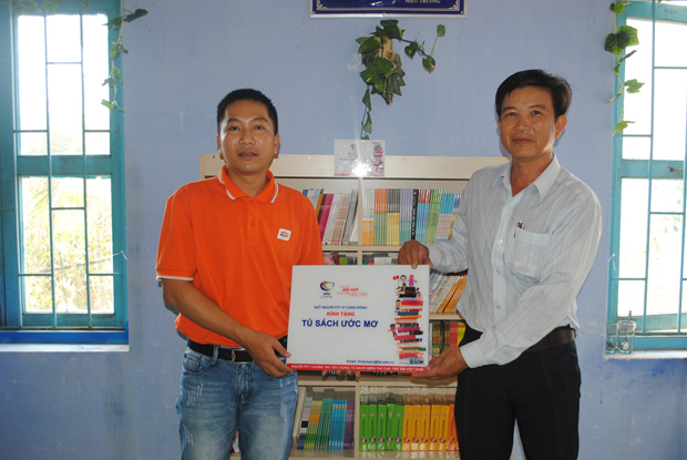 Đoàn thiện nguyện FPT trao tủ sách ước mơ cho đại diện nhà trường.