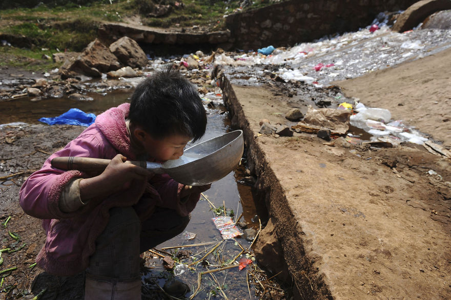 <p> Một bé trai uống nước gần một dòng suối ở quận Fuyuan trong tỉnh Vân Nam, Trung Quốc.</p>