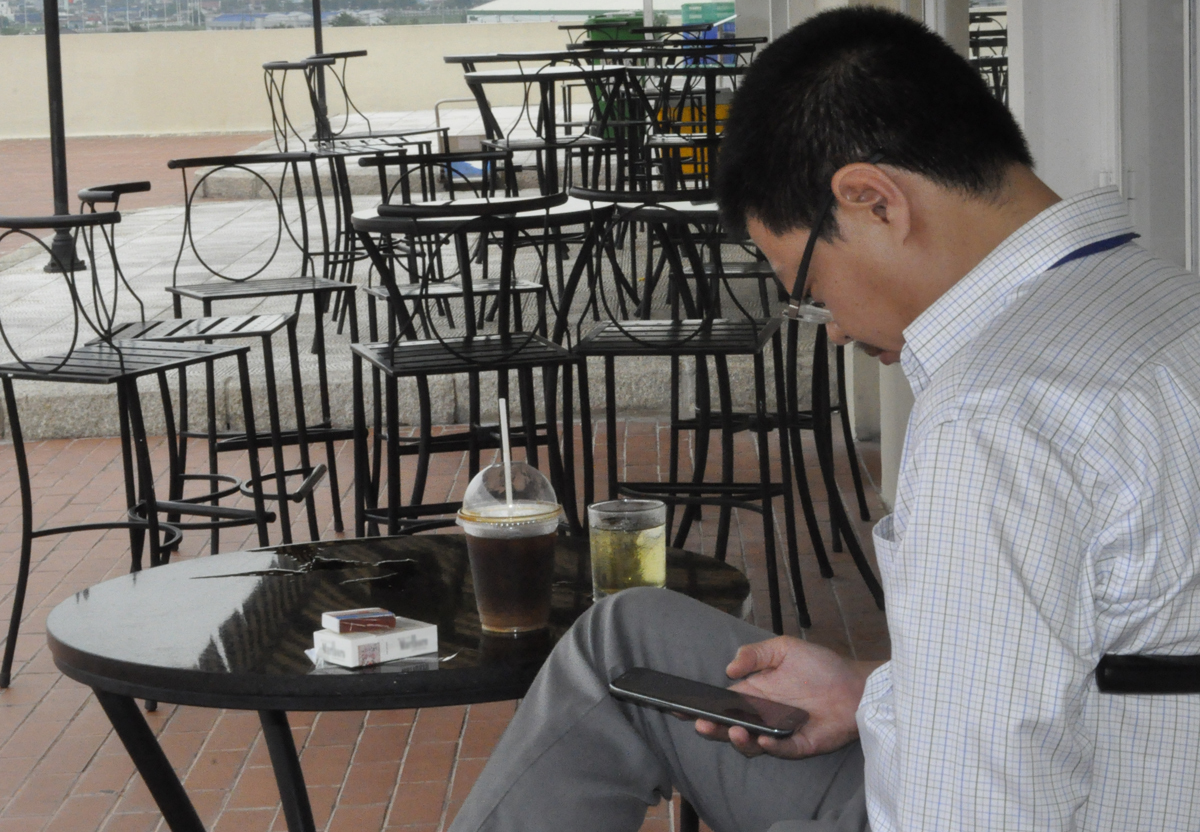 <p> Anh Trần Thành Trung, GĐ FSU17 HCM, xử lý e-mail trên di động bên cạnh ly cà phê và bao thuốc lá tại khu Cafeteria, tầng 3, F-Town 1.</p>