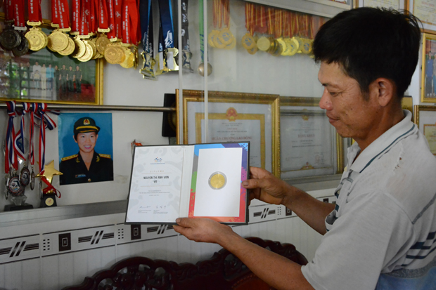 Bác Nguyễn Văn Tác bên bộ sưu tập huy chương, bằng khen đồ sộ của con gái Ánh Viên.