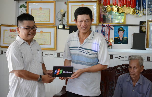 Anh Huỳnh Chấn Cầu (bên trái) đại diện FPT Retail trao tặng món quà