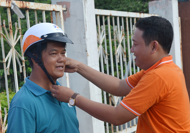 <p> Anh Lâm Khánh Phương, PGĐ FPT Telecom Bình Dương, trao tặng mũ cho người dân địa phương.</p>