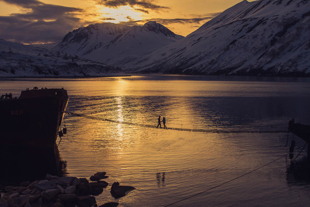<p> Kamchatka, Liên bang Nga. Mặt trời sau rặng núi tuyết, phủ ánh sáng nhạt loang loáng trên mặt hồ.</p>