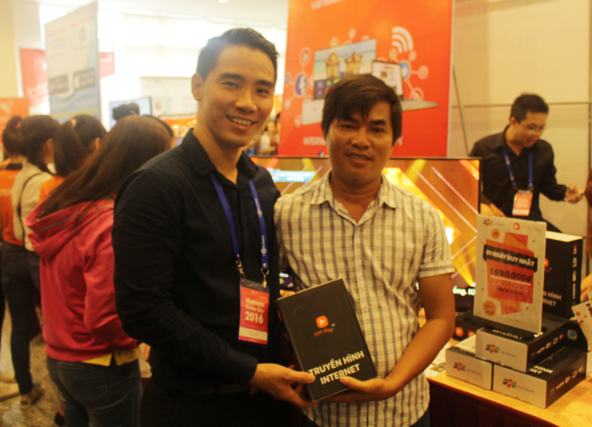 <p class="Normal"> Anh Phan Hải Đăng (bên trái, Ban dự án), trao FPT Play Box cho một khách hàng.</p>