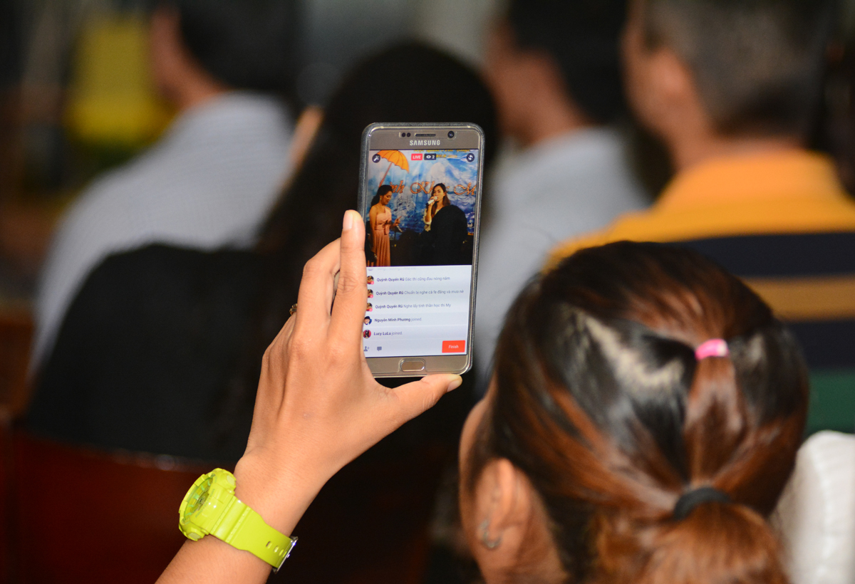 <p> Ngoài những tràng pháo tay cổ vũ ca sĩ Thanh Ngọc và các thành viên Đoàn Văn công FPT HCM, nhiều khán giả còn dùng smartphone ghi lại những các khúc của chương trình cũng như tường thuật Live stream trên Facebook. </p>