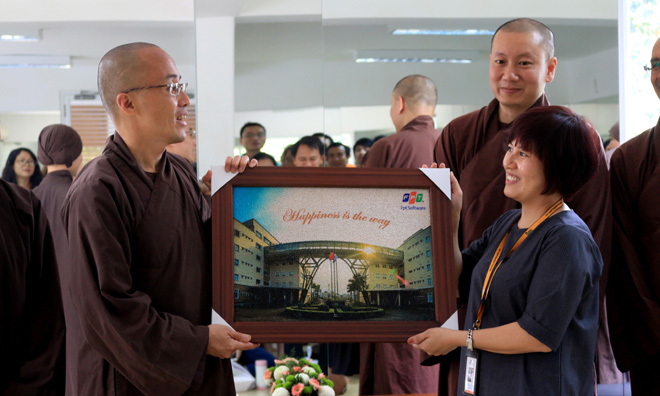 <p> Chị Nguyễn Thị Vọng, Trưởng phòng Đào tạo FPT Software, tặng thầy Pháp Dung và các tu sĩ bức ảnh chụp tòa nhà F-Town. </p>