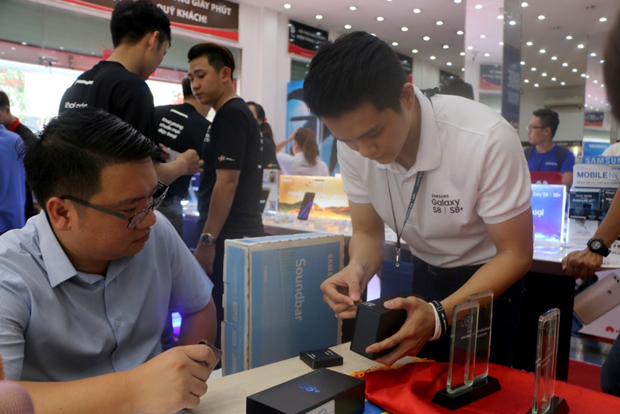 Nhân viên bán hàng đang mở hộp Galaxy S8 cho những khách mua hàng đầu tiên trong ngày mở bán.