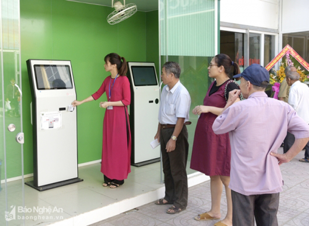 Người khám bệnh xếp hàng quẹt thẻ BHYT tại Bệnh viện Đa khoa thành phố Vinh. Ảnh: Báo Nghệ An.