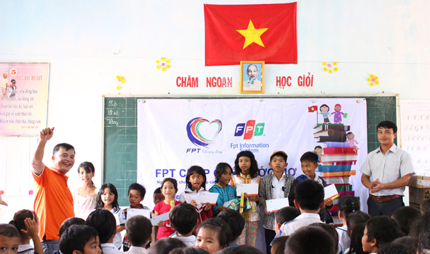 Anh Đoàn Việt Hà (áo cam), PTGĐ FPT IS ENT HCM, đại diện đoàn trao 40 suất học bổng cho học sinh nghèo vượt khó, mỗi suất 300.000 đồng.