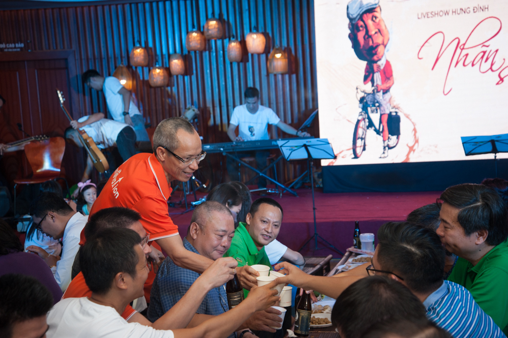 <p> Người ta đến đêm nhạc không chỉ vì cảm mến con người của "nghệ sĩ dân tộc" FPT Nguyễn Duy Hưng (Hưng "Đỉnh", FPT Trading), để nghe hát mà còn để gặp những con người đã và đang làm nên văn hóa của tập đoàn.<br /><br /> Nhạc vang lên. Rượu rót đầy ly và cảm xúc cứ thế tuôn trào trong từng khúc ca, từng cái bắt tay. <br /><br /> Trong ảnh, Hiệu trưởng ĐH FPT Hà Nội, Viện sĩ STCo Nguyễn Khắc Thành (áo cam) chúc rượu các đồng nghiệp đến dự liveshow. Anh Thành là người đầu tiên ở FPT có một liveshow mang tên "Một chút Khắc Thành", tổ chức năm 2003.</p>