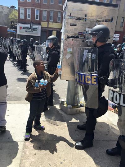 <p> Cậu bé này đang tặng một chai nước cho cảnh sát sau vụ bạo loạn ở Baltimore, Mỹ.</p>