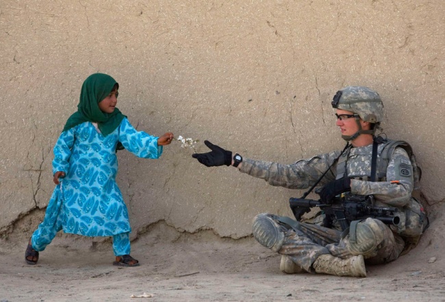 <p> Một người lính Mỹ nhận hoa từ một bé gái Afghanistan khi đang tuần tra ở thung lũng Arghandab ở Afghanistan.</p>