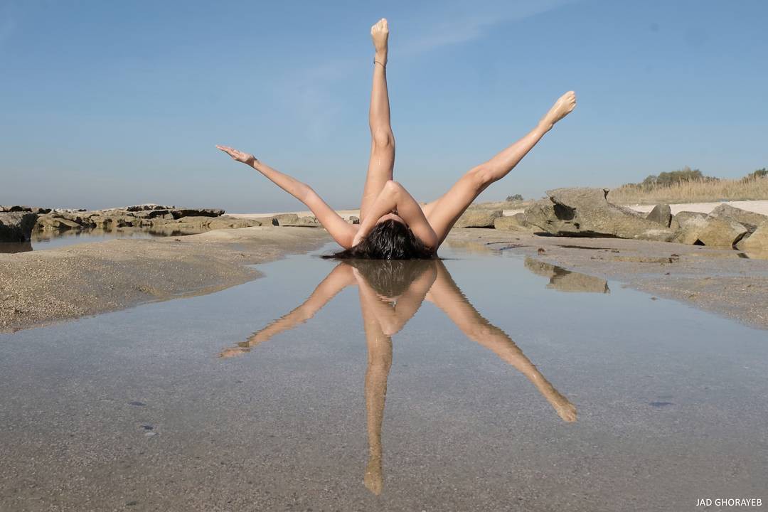 <p> Người tập Yoga trên bãi biển qua hình ảnh phản chiếu của nước. </p>