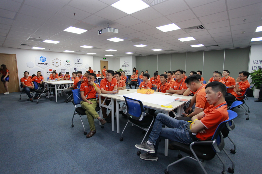 <p class="Normal" style="text-align:justify;"> Đồng hồ điểm 3h, người tham gia đến ngày càng đông. Mỗi người được phát dải ruy băng phân đội theo màu, dán sticker. Tổng cộng có 5 đội được chia. Mở đầu, anh Trần Bảo Hiếu - Trưởng phòng chất lượng TIN - trình bày hiện trạng, mục tiêu trong thời gian tới. Anh Hiếu chia sẻ trong 30 phút. Bài phát biểu được rút gọn trong một slide bằng đồ thị, số liệu.</p>