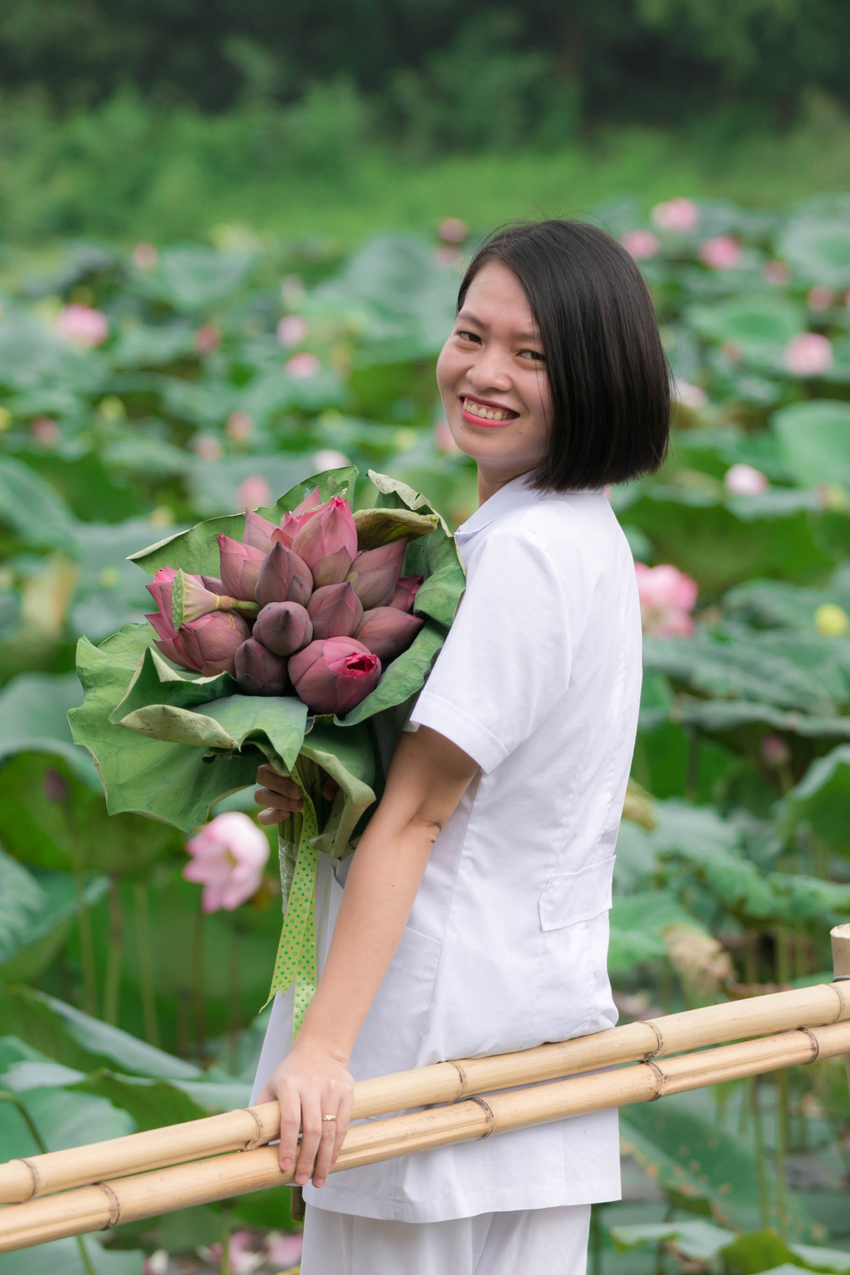 <p> Chị Thiều Thị Hằng, cán bộ tổ Y tế, cũng tranh thủ chụp ảnh cùng bó hoa sen.</p>