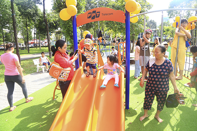  "Con rất thích được chơi ở đây", bé Quang Minh (4 tuổi) chia sẻ chơi cầu trượt. Công viên Làng Hoa là khu vực tập trung đông đảo người dân địa phương đến tập thể dục và vui chơi hằng ngày.