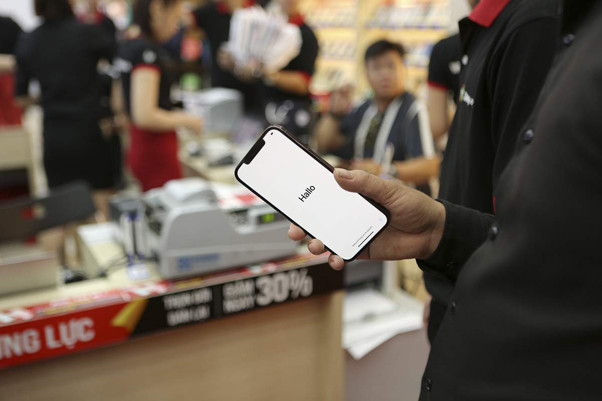 <p> Khách hàng "bóc tem", khởi động iPhone 12 ngay sau khi nhận máy tại cửa hàng.</p>