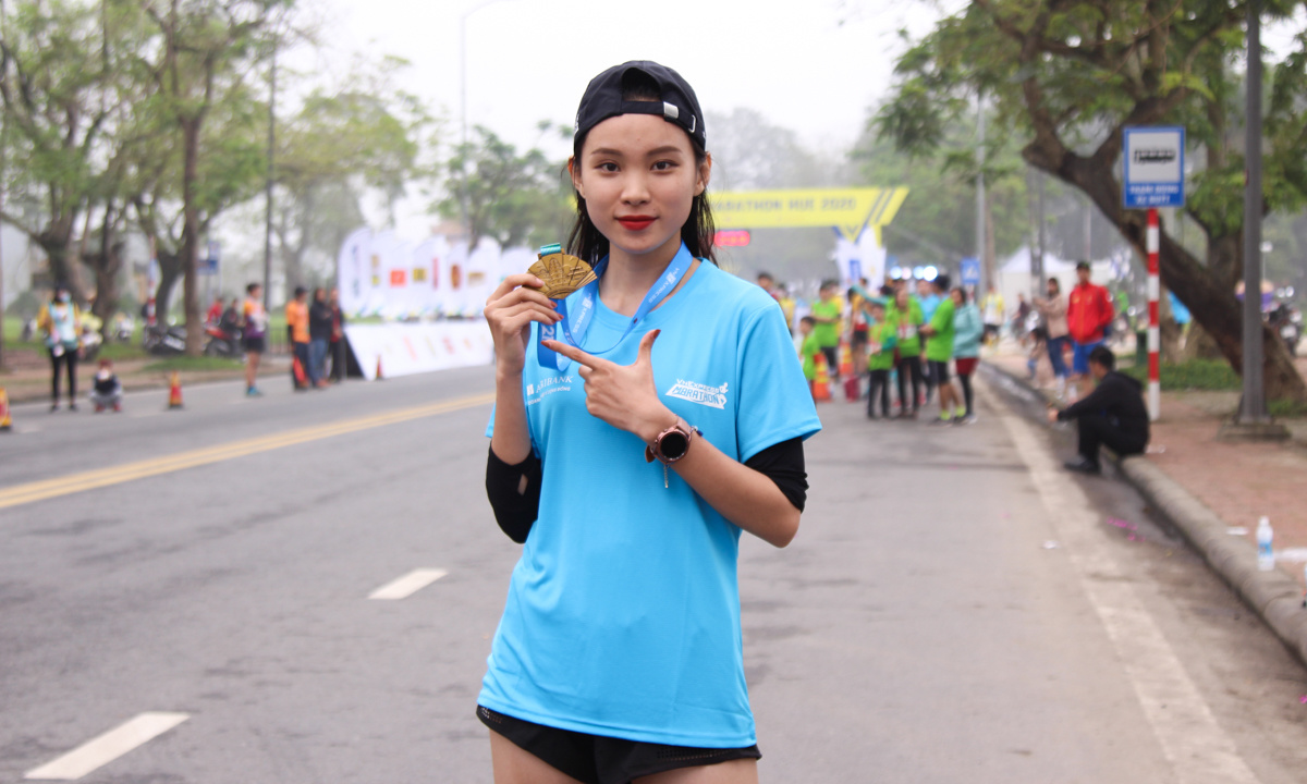 <p> Chị Hồ Thị Ngọc Hiếu (FPT Software) tự tin khoe tấm huy chương ở cự ly 21 km vừa giành được. </p>