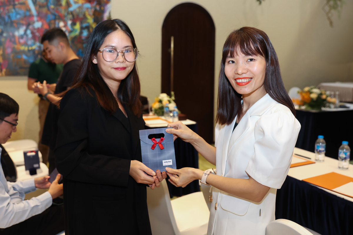 <p> Chị Phạm Thị Vân Anh, Ban Marketing - Truyền thông FPT (phải) trao quà kèm thư mời cho khách.</p>