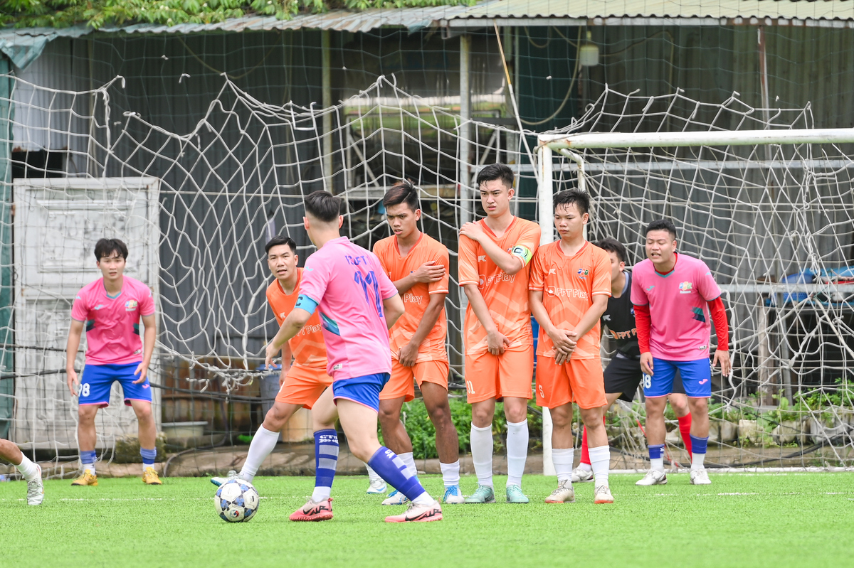 <p class="Normal" style="text-align:justify;"> Trận bán kết 1 của nhánh vàng giữa FSOFT 1 (áo hồng) và FTEL FPT PLAY (áo cam) là màn tái hiện trận chung kết mùa 2024, và lần này chiến thắng đã gọi tên đại diện nhà Phần mềm.</p> <p class="Normal" style="text-align:justify;"> Ngay từ đầu trận, hai đội thi đấu đầy toan tính với những pha tranh chấp quyết liệt. FTEL FPT PLAY có cơ hội nguy hiểm đầu tiên với cú đánh đầu sát cầu môn của Nguyễn Ngọc Tân, nhưng bóng đi chệch khung thành trong gang tấc.</p> <p class="Normal" style="text-align:justify;"> Phút 24, FSOFT 1 được hưởng tình huống đá phạt, đội trưởng Việt Thắng tung cú sút sệt như phá làm khó thủ môn, để rồi Đức Long chớp thời cơ đưa bóng vào gôn. Sau bàn thua bất ngờ, đại diện nhà Viễn thông tràn lên tấn công tìm kiếm bàn gỡ, nhưng cũng dần để lộ kẽ hở hàng phòng ngự.</p>
