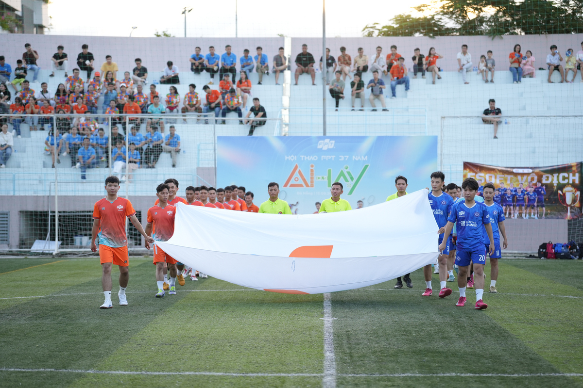 <p class="Normal" dir="ltr"> Buổi chiều, tâm điểm chuyển sang sân F-Complex với trận chung kết FPT Cup 2025 giữa đại diện nhà Phần mềm &lpar;áo xanh&rpar; và đại diện nhà Viễn thông &lpar;áo cam&rpar;. Đông đảo cổ động viên mang theo cờ, trống, băng rôn, lấp kín khán đài trong sắc cam, tạo nên bầu không khí sôi động, náo nhiệt.</p>