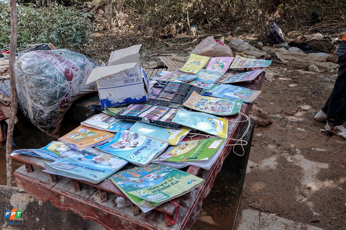 <p> Các cô chú áo cam cẩn thận phơi lại những tập sách đã ngấm trong bùn đất. Xung quanh là khung cảnh tan hoang.</p>