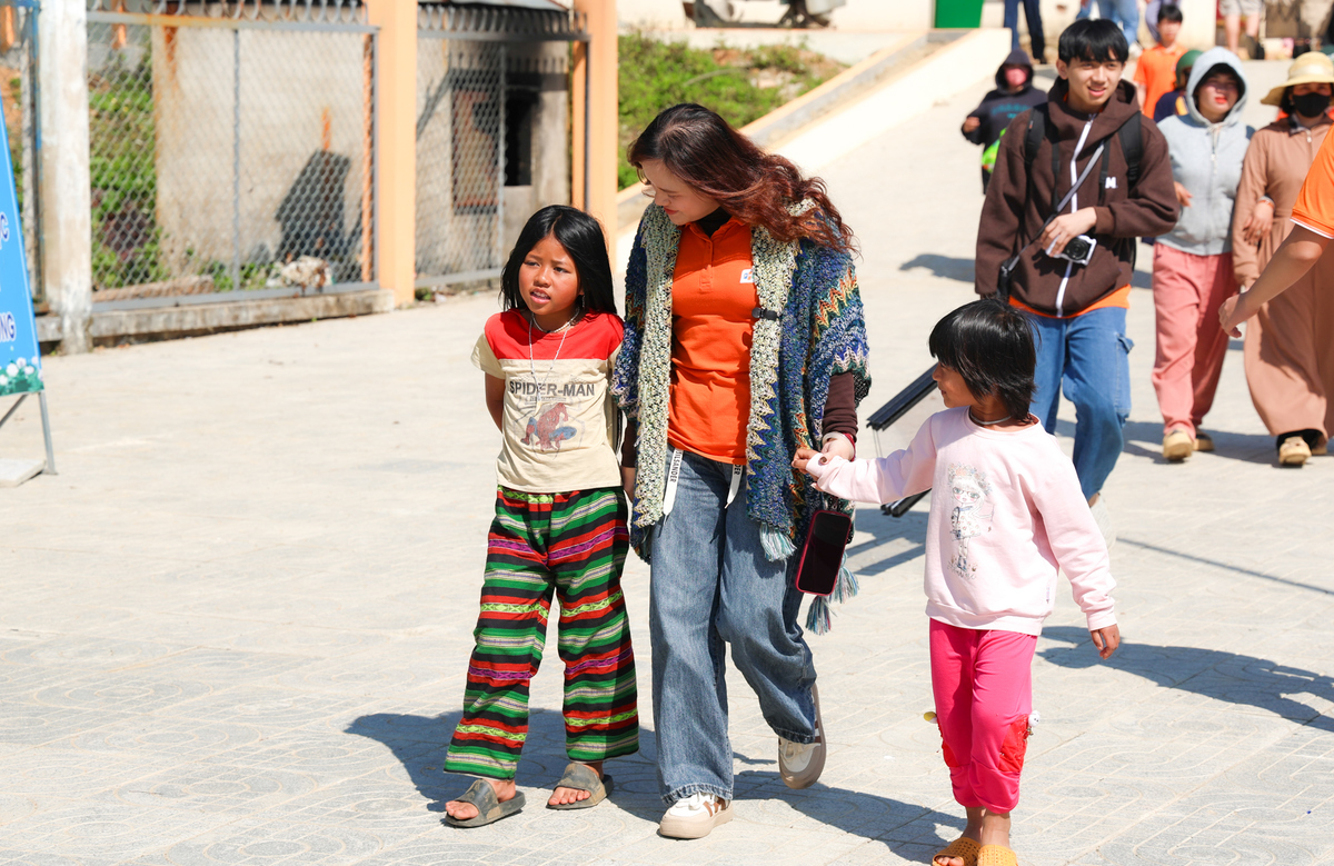 <p> Còn với cô giáo Quách Thị Diên, g<span>iữa khung cảnh núi rừng quen thuộc, những ký ức về quãng thời gian mới ra trường, từng công tác nhiều năm tại vùng núi xa xôi lại ùa về - khi cô còn là người giáo viên trẻ, cùng học trò đón nhận những chuyến xe thiện nguyện đầy ấm áp. </span><span>“Ở thời điểm đó, tôi là người nhận yêu thương. Còn hôm nay, khi được trực tiếp mang yêu thương đi trao, tôi càng thấm thía hơn giá trị của sự sẻ chia, như một vòng tròn nhân ái được tiếp nối". <em>Trong ảnh: Cô Diên nắm tay 2 em nhỏ ở xã Hùng Sơn.</em></span></p>